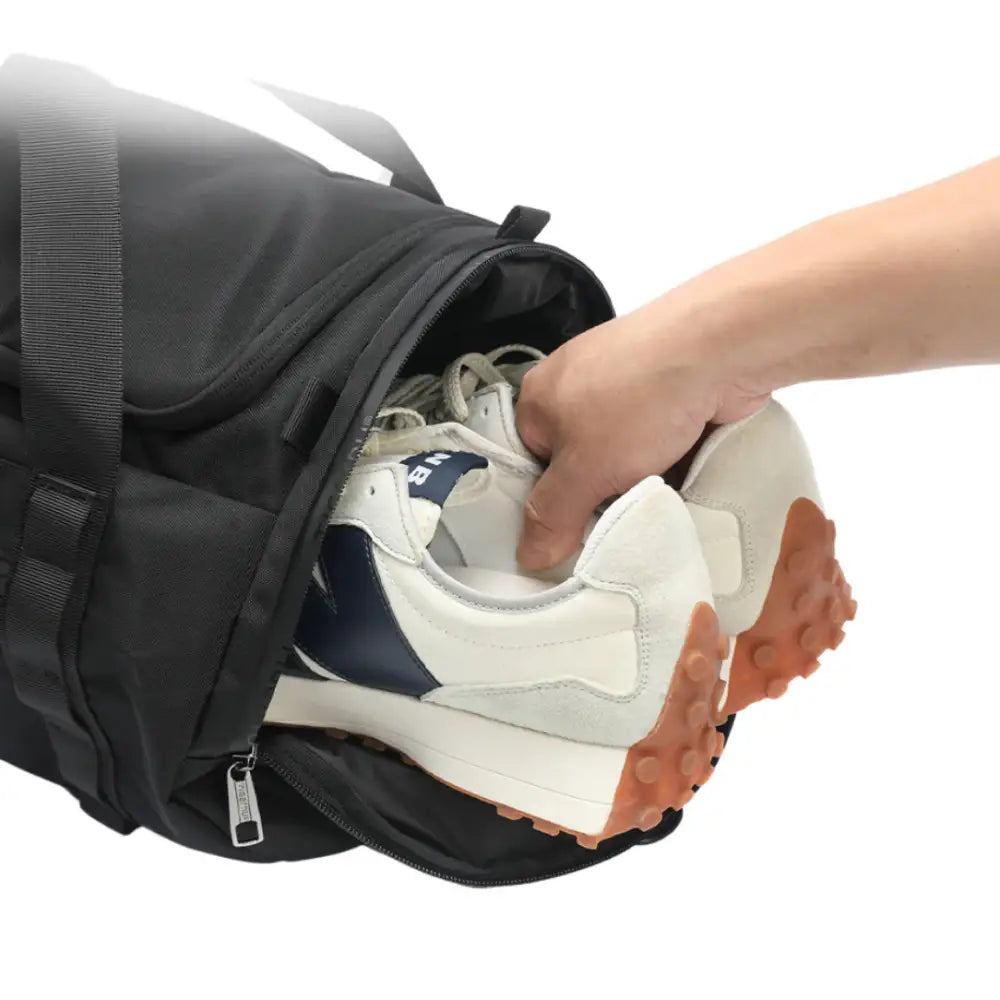 Sac de sport noir avec des chaussures placées à l’intérieur.