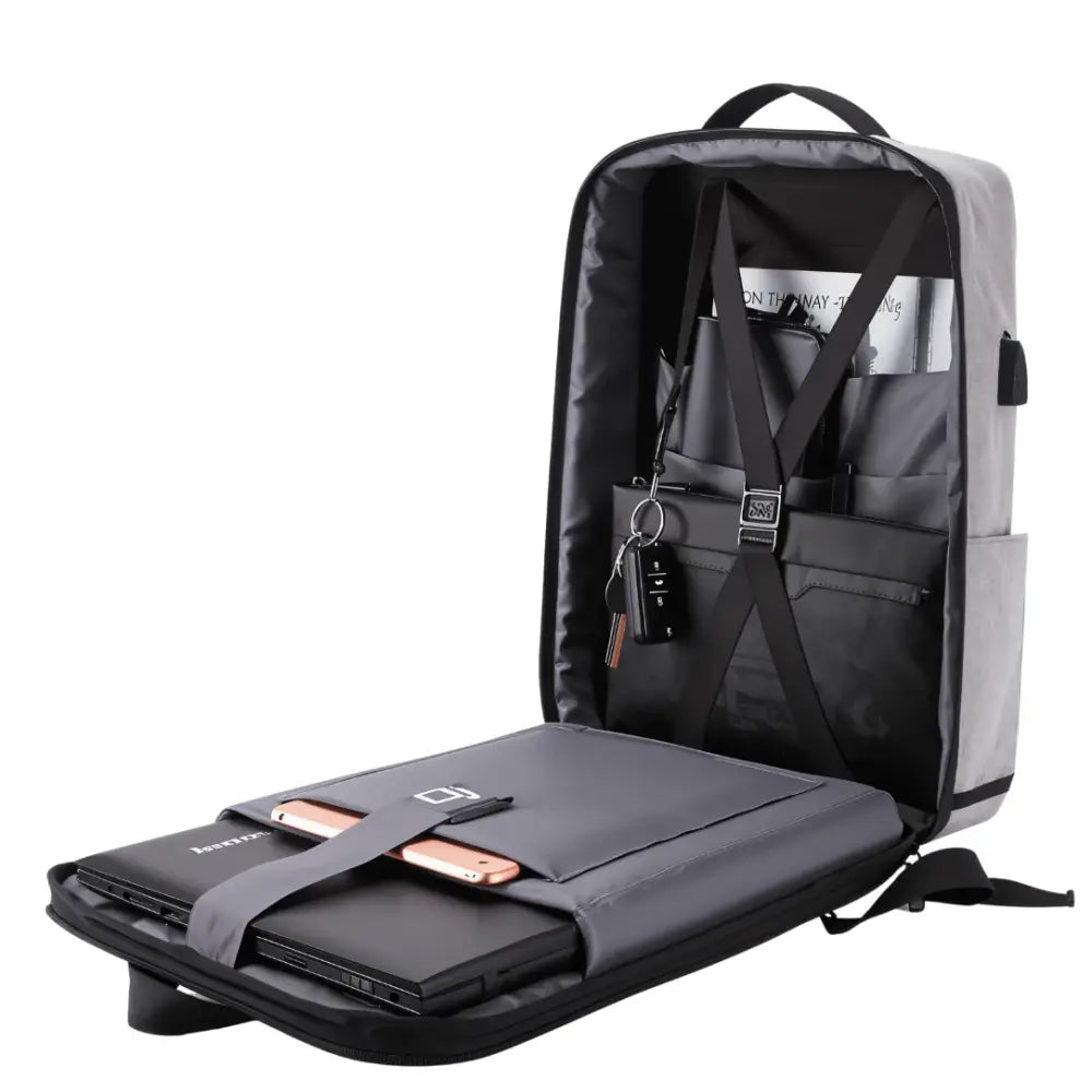 Petit sac à dos antivol Lite S gris ouvert avec ordinateur portable et téléphone, cadenas TSA