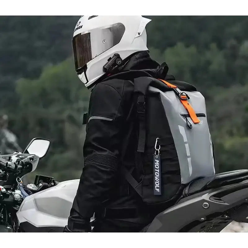 Motocycliste avec un sac à dos gris et noir.