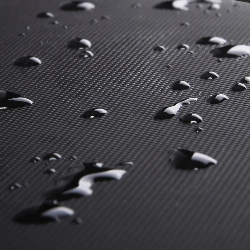 Gouttes d’eau sur un matériau noir texturé.