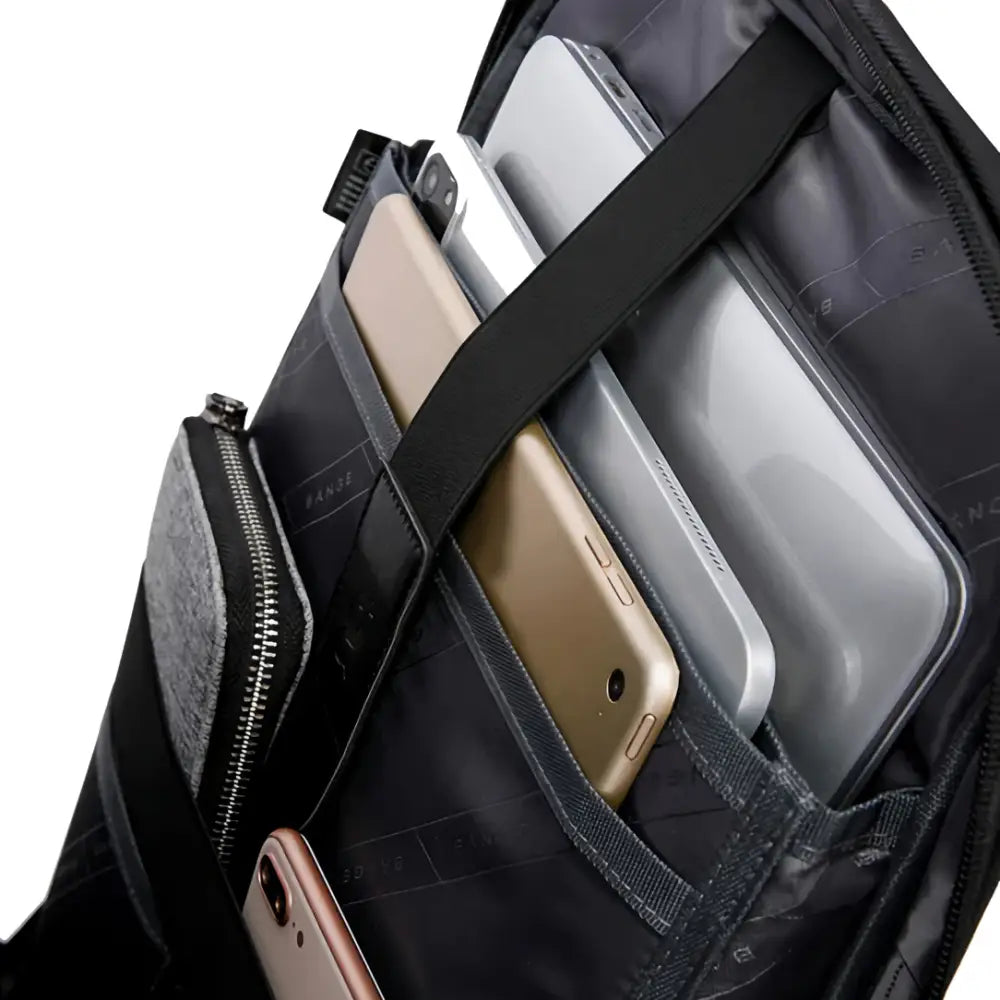 Sac à dos noir ouvert contenant des appareils électroniques.