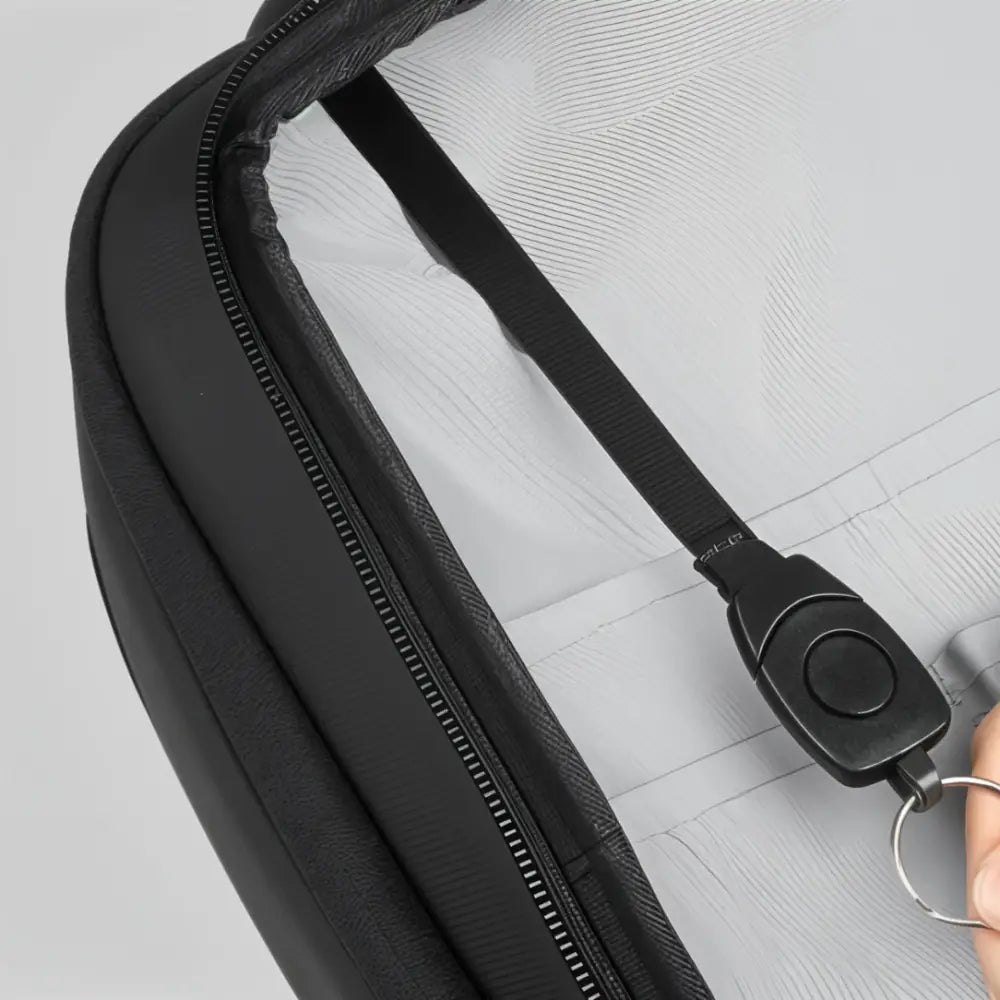 Sac noir ouvert à fermeture éclair avec lanière pour les clés.