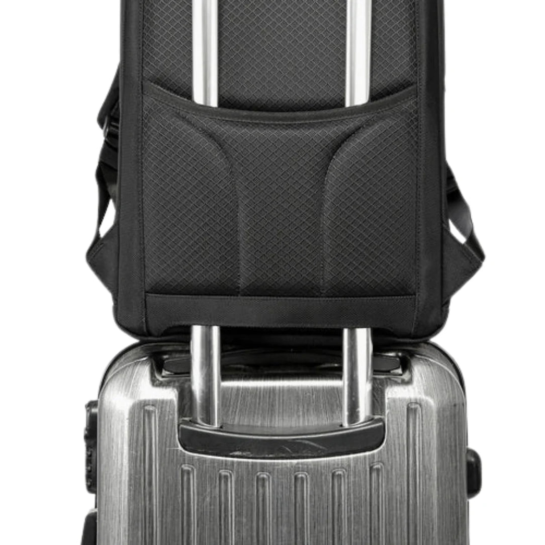 Sac à dos noir sur valise argentée.