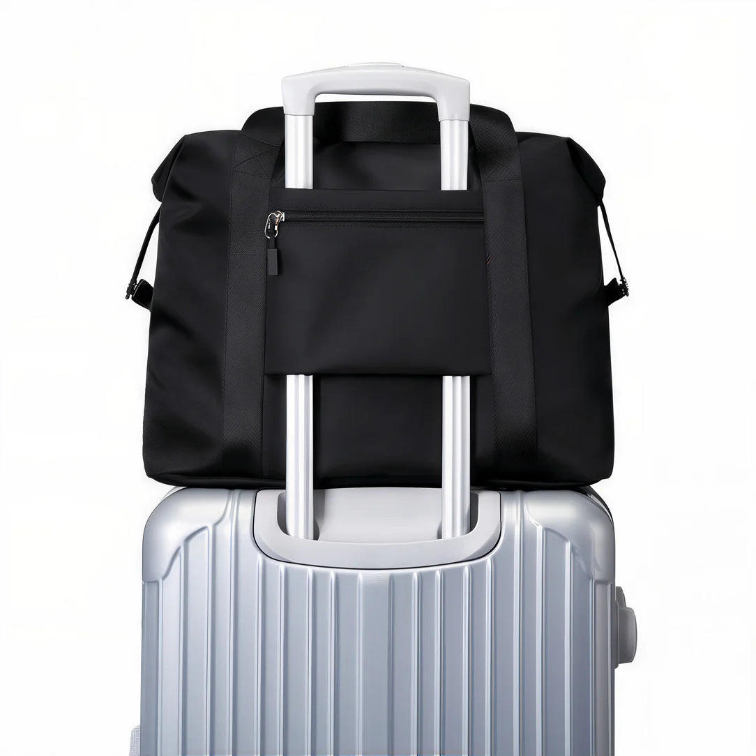 Sac à main de voyage Valmir avec sac noir duffel sur valise argentée