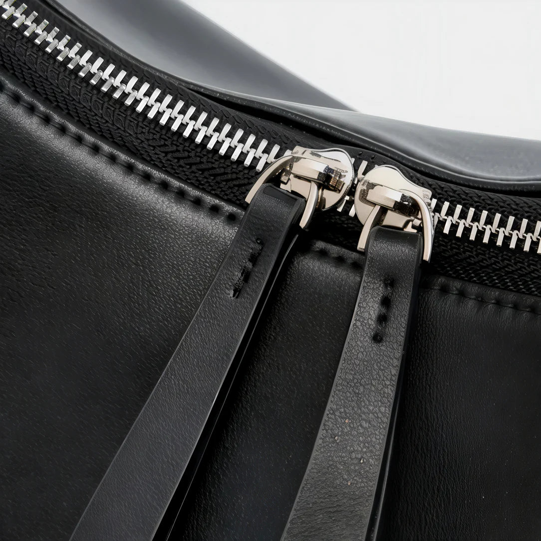 Sac à main demi lune en cuir noir avec fermeture éclair argentée, style main demi lune