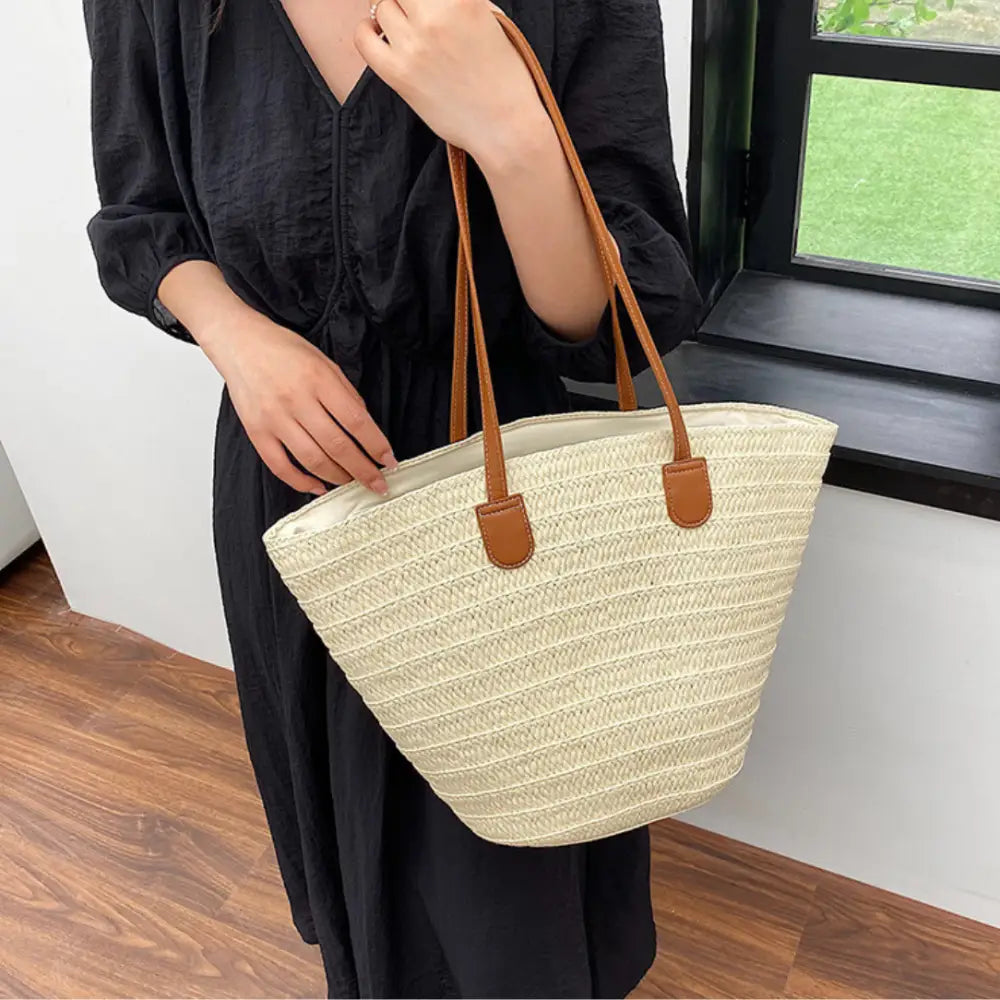 Sac à main en paille avec anses en cuir marron, parfait pour un look bohème