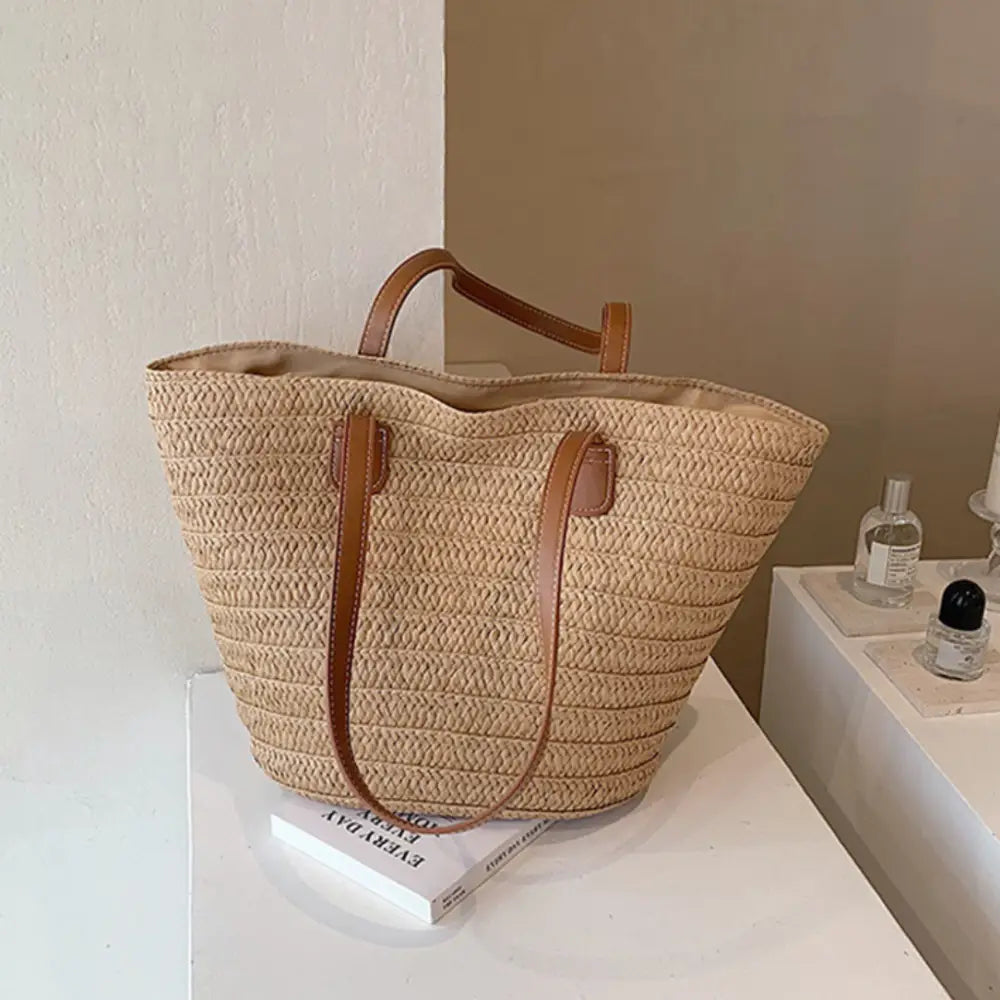 Sac à main en paille avec anses en cuir marron, parfait pour l’été