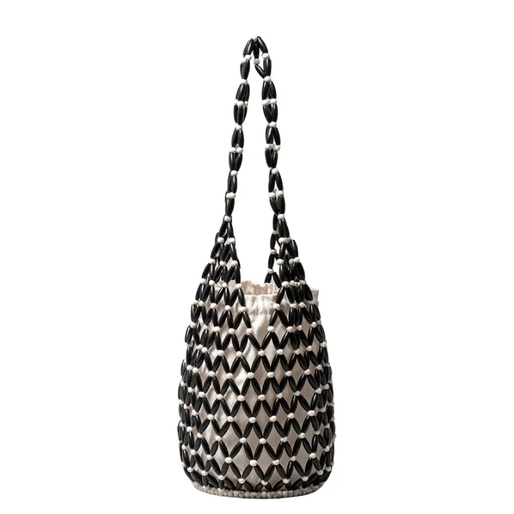 Sac de plage Cala avec design aéré noir et blanc, parfait pour un style naturel cet été