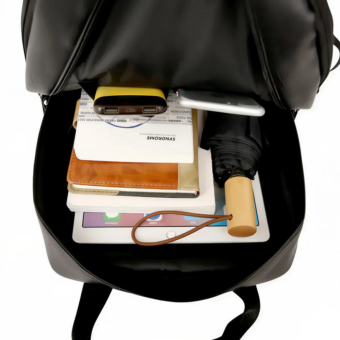 Sac à dos homme en similicuir Ebonor noir avec divers objets à l’intérieur