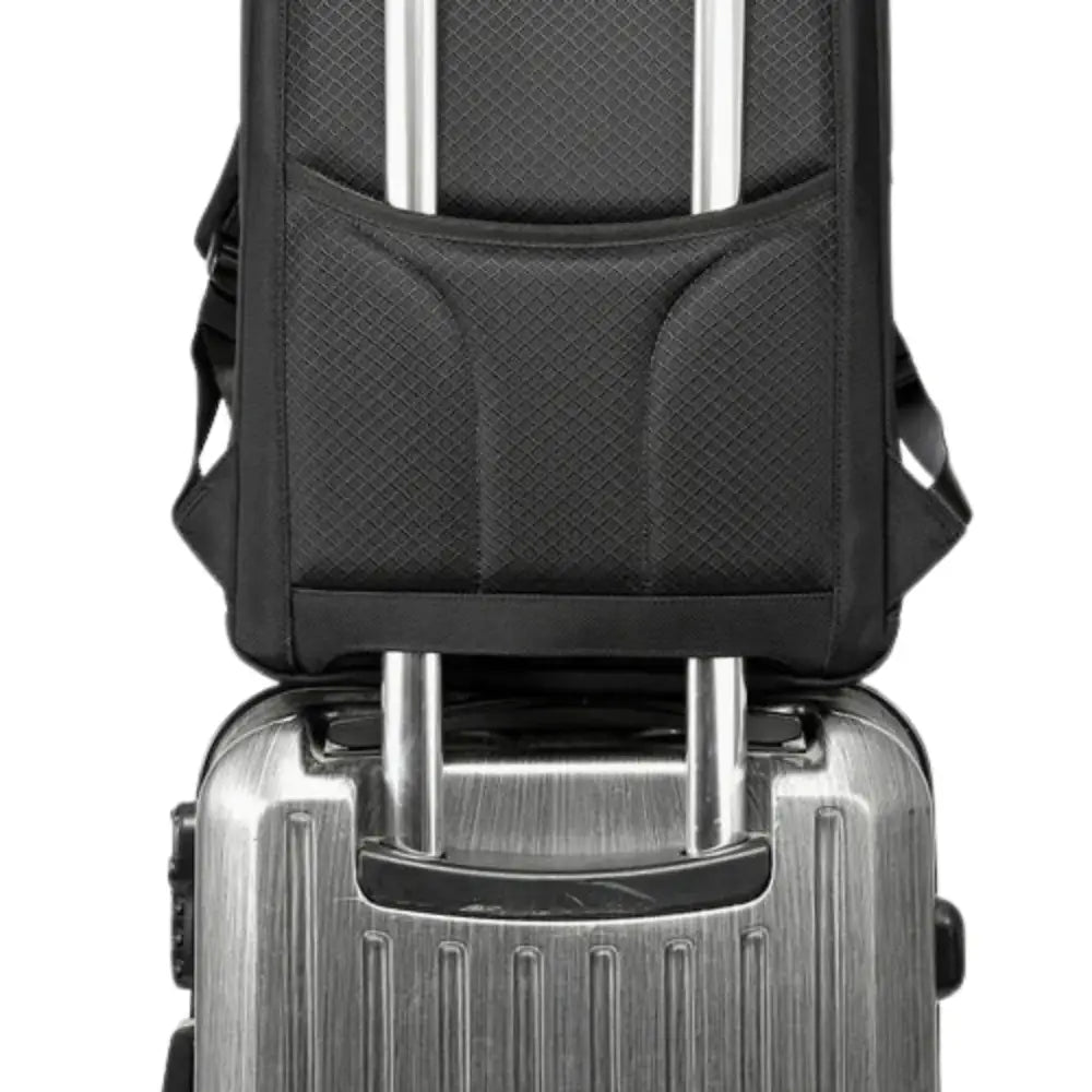 Sac à dos noir sur valise argentée.