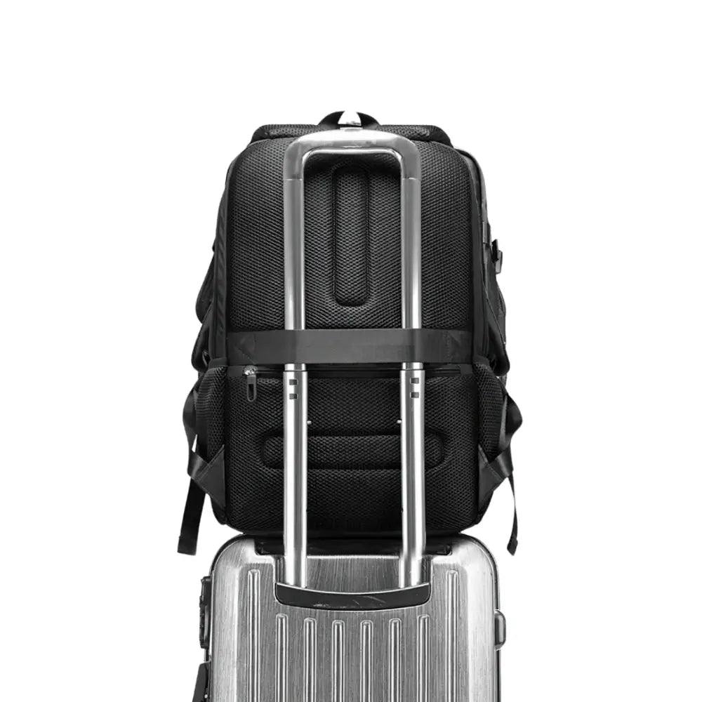 Sac à dos noir sur valise argentée.