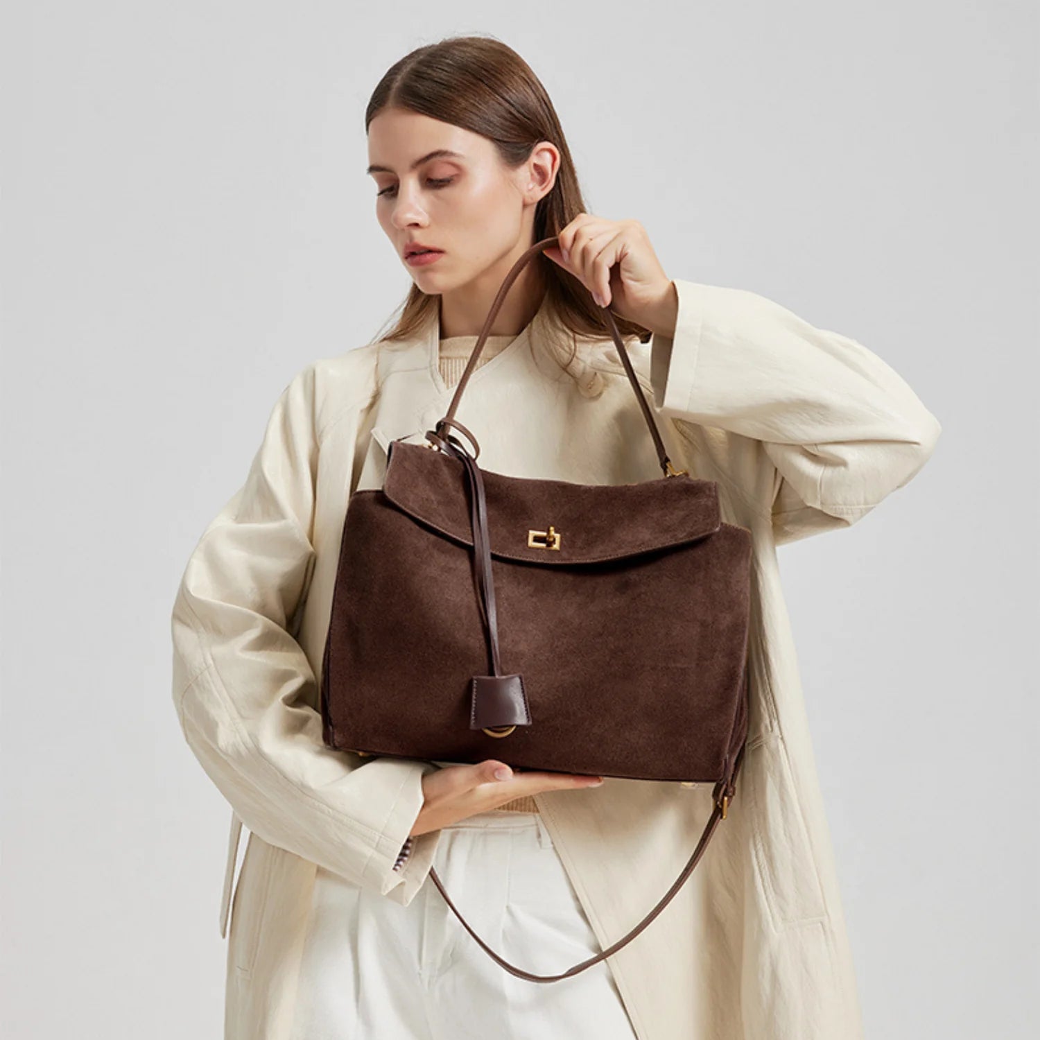 Sac à main de cours capucine en daim souple brun avec fermeture à clapet dorée et bandoulière en cuir assortie